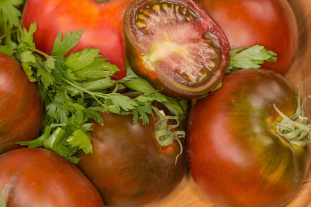 Half of the ripe green-brown tomato kumato lie on the same whole tomatoes, fragment close-upの写真素材