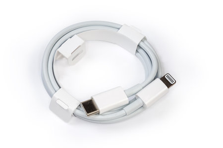 Coiled white cable with plugs USB Type-C and Lightning at the edges on a white backgroundの写真素材