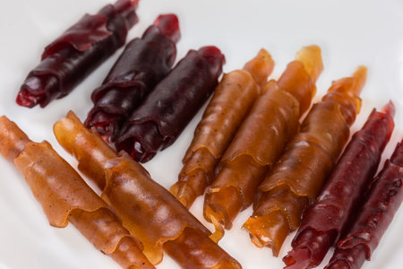 Natural thin soft flexible pastila made with apple puree drying at low temperature and rolled into tubes, close-up in selective focusのeditorial素材