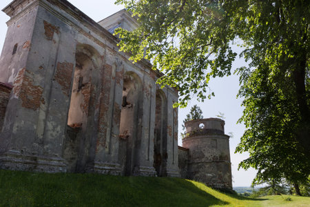 Bell tower of the former fortified medieval Dominican Monastery in the form of horizontal building with arcades in the Pidkamin village, outside view in spring sunny day, Ukraineのeditorial素材