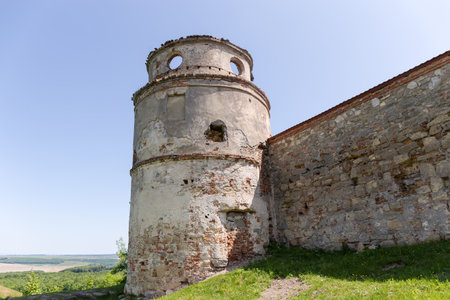 Former fortified Dominican Monastery 15th century, outside view of the round corner defensive tower and part of wall against the clear sky, Pidkamin village, Ukraineのeditorial素材