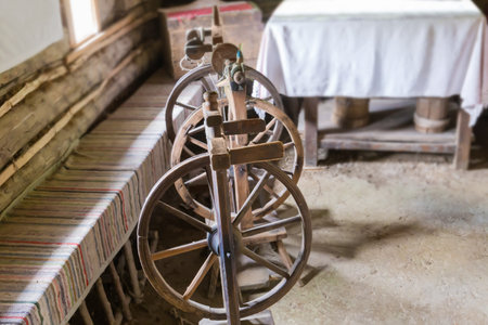 Several old rustic wooden spinning wheels, type of upright wheel with foot drive, selective focus