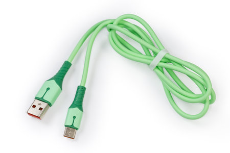 Twisted green USB cable with plugs standard A and standard C at the edges on a white backgroundの写真素材