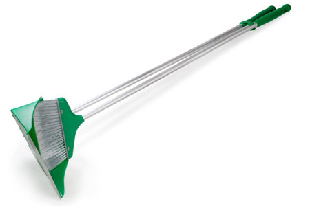 Kit of the green plastic broom with gray bristles and dustpan with long metal handles for sweeping floors on a white backgroundの写真素材