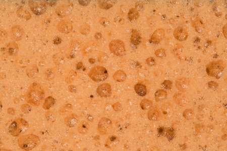 Texture of the brown synthetic material of the soft kitchen cleaning sponge, top view close-upの写真素材