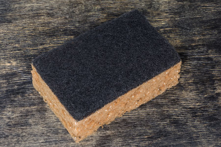 Kitchen soft synthetic cleaning sponge with hard urethane abrasive layer on a black surfaceの写真素材