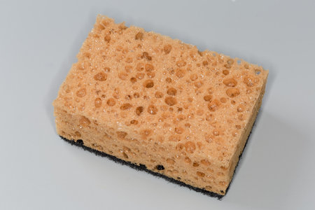 Kitchen soft synthetic cleaning sponge with hard urethane abrasive layer on a gray backgroundの写真素材