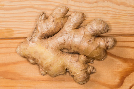 Piece of the washed fresh ginger root on a wooden rustic table, top viewの写真素材