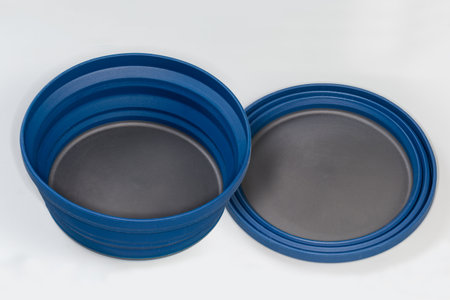 Two empty tourist foldable bowls made of food-grade flexible thermosilicone in the folded and unfolded state on a gray surfaceの写真素材