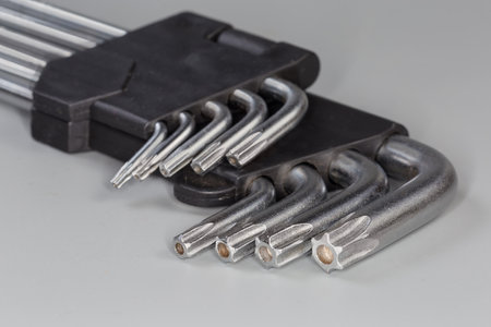Set of L-keys of different sizes with 6-point star-shaped tips with holes, also known as hexalobular internalonas, as official name on a gray surface, fragment close-up in selective focusの写真素材
