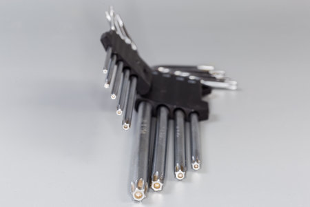 Set of L-keys of different sizes with 6-point star-shaped tips with holes, also known as hexalobular internalonas, as official name on a gray surface, close-up in selective focusの写真素材
