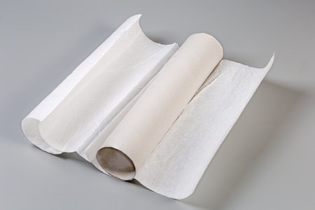 Last remaining sheets of the disposable paper towels on a cardboard tube after the rest has been used of the main part of towel roll on a gray surfaceの写真素材