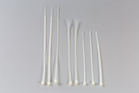 Several unfastened single-use nylon white translucent cable ties of different lengths on a gray background, top viewの写真素材