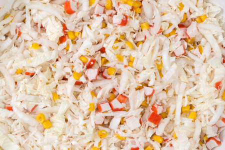 Surface of the prepared salad of chopped crab sticks and napa cabbage and sweet corn, top view, backgroundの写真素材