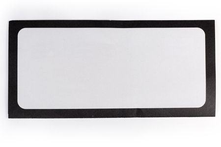 Closed blank flat rectangular mailing envelope made with white paper with black frame around the perimeter on a white background, top viewの写真素材