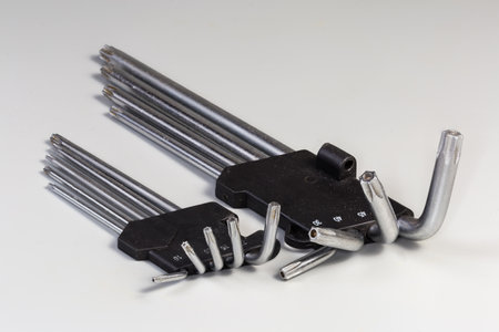 Two sets of L-keys of different sizes with 6-point star-shaped tips with holes, also known as hexalobular internalonas on a gray surfaceの写真素材
