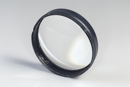 Old simple spherical lens with one convex surface and other flat surface, so-called plano-convex lens in the metal frame a gray backgroundの写真素材