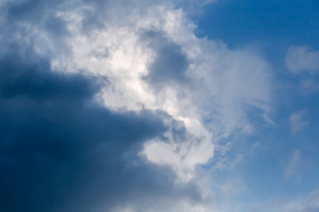 Section of the sky with edge of dense dark storm cloud against the blue skyの写真素材
