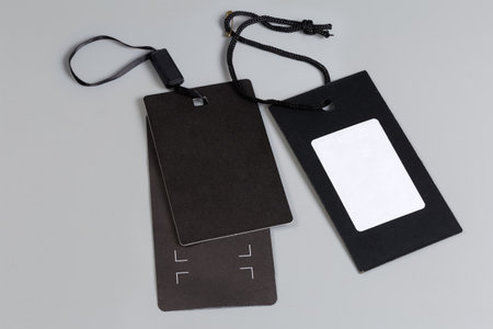 Two sale clothing swing tags in the form of the blank black cardton sheets on a black rope and...
