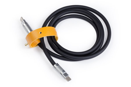 Coiled black thick cable USB with plugs USB Type-C at the both edges on a white backgroundの写真素材
