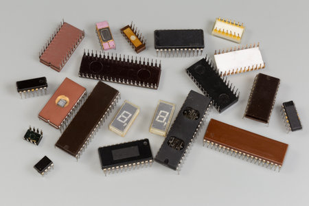 Digital integrated circuits various purposes in rectangular plastic and ceramic dual in-line packages with pins for thru-holes mounting on printed circuit board on a gray surfaceの写真素材