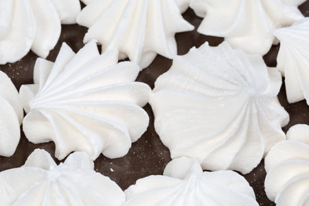 Meringue cookies on a brown dish, top view close-up in selective focusの写真素材