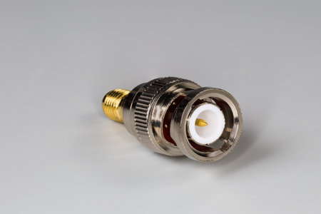 High-frequency coaxial adapter with connectors BNC and SMA type on the edges on a gray surfaceの写真素材