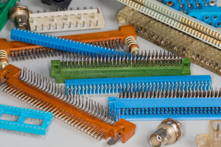 Heap of various male and female electrical connectors of different design for different purposes on a gray surface, selective focusの写真素材