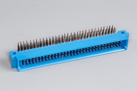 Three row male electrical connector in blue plastic housing with right angle terminals which may be soldered to the printed circuit board, view on a gray surface in selective focusの写真素材