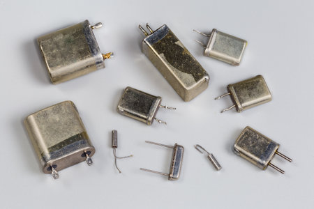 Old crystal oscillators designed for different operating frequencies in the metallic hermetically packages used for various purposes on a gray backgroundの写真素材