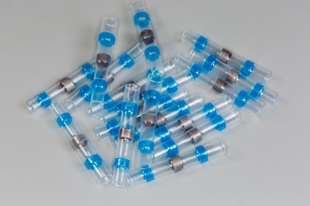 Heap of blue heat shrink tubes with solder ring inside in center, so called solder sleeves for...