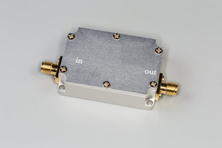 Miniature high-frequency electronic unit in closed shielding metal housing with two yellow coaxial connectors on a gray backgroundの写真素材