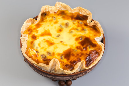Hot baked sweet casserole made with cottage cheese, eggs and sugar in flat bread in a clay bowl on a...