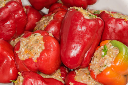 Heap of raw bell pepper stuffed with rice and chopped meat, which requiring final cooking, close-up in selective focusの写真素材
