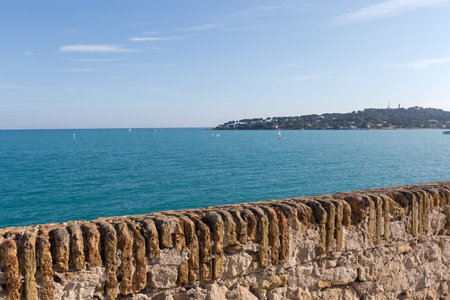 Ancient parapet made with stone and old red brick on a shore of the sea bay in sunny dayの写真素材