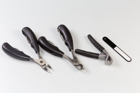 Set of different professional stainless steel nail clippers of different design and nail file for grooming of thick and ingrown nails on a gray backgroundの写真素材