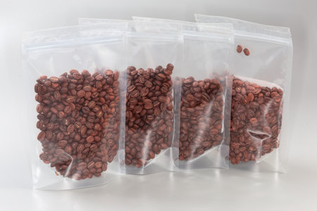 Roasted coffee beans in the plastic food-grade rectangular transparent reclosable zipper storage...