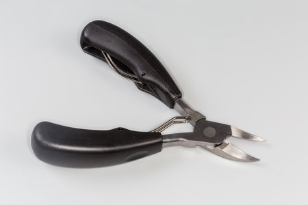 Professional stainless steel pedicure nail clipper with curved blades for grooming of thick and ingrown nails on a gray backgroundの写真素材