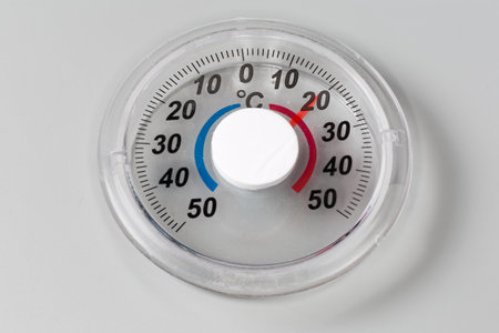 Round mechanical outdoor thermometer with bimetal coil and Celsius scale, designed to attached to...