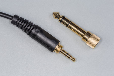 Plug mini-Jack on edge of analog audio stereo cable and metal screwable adapter mini-Jack to Jack of...