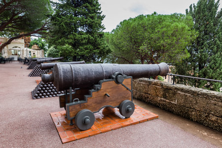 Row of medieval cannons and heaps of cannon balls on top of Rock of Monaco in Old town at autumn overcast day, Principality of Monaco,の写真素材