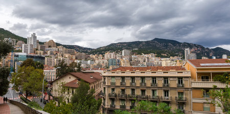 Panorama of urban building in the eastern part of Monaco against the mountains and cloudy sky,...