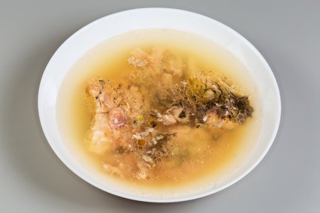 Jellied fish made with carp in the white bowl on a gray backgroundの写真素材