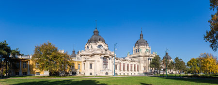 Neo-Baroque building of SzÃ©chenyi Thermal Baths, built in early 20th century in Budapest, panoramic view from main entrance side against the clear sky at autumn sunny dayの写真素材