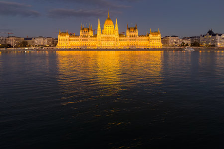 Main facade of the Hungarian Parliament Building with night lighting, view from the west bank of the Danube at evening, Budapestの写真素材