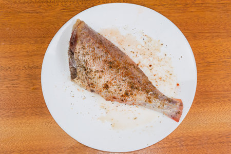 Raw gutted defrosted carcass without head of redfish, also known as ocean perch marinated in spices...