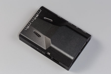 Small electronic unit in the flat rectangular plastic housing with various electric connectors...