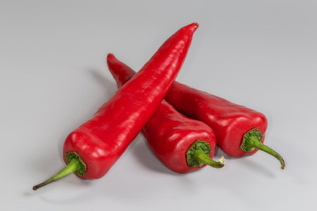 Several ripe red sweet peppers kind of Kapia in form of a long pods on a gray backgroundの写真素材
