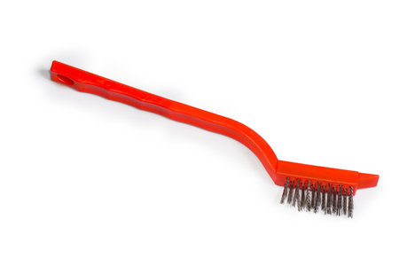 Manual brush with bristles of the steel corrugated wire on red plastic handle on a white backgroundの写真素材