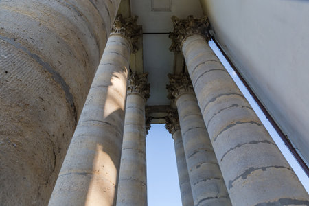 Upper part of round stone columns of Corinthian order hewn of sandstone in portico of the facade of...